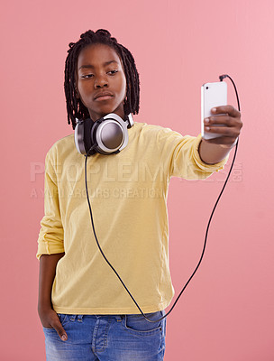 Buy stock photo Teen, boy and selfie of student in studio with headphones for listening to music and post on social media. High school, kid and live streaming on blog with pride and confidence in profile picture