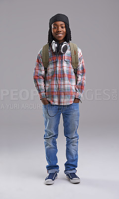 Buy stock photo Headphones, happy and portrait of child on gray background for listening to song, audio and radio. Fashion, student and young African boy with bag in trendy style, clothes and outfit in studio