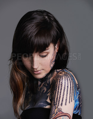 Buy stock photo Creativity, ink and woman with tattoo in studio for creative design, trendy and body art with color. Female person, funky and edgy with artistic, blue and red for bold statement in gray background