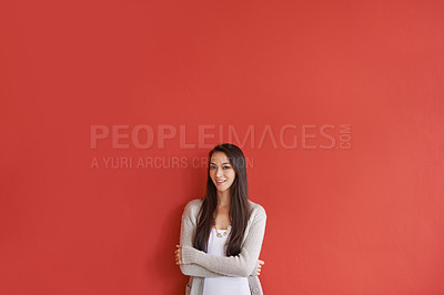 Buy stock photo Portrait of an attractive young woman standing against a red background
