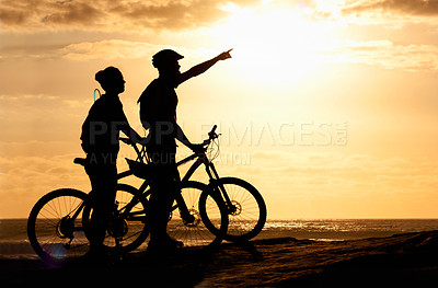 Buy stock photo Silhouette of a couple with their bicycles on the beach