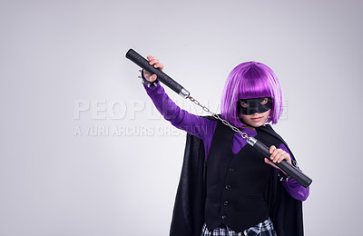 Buy stock photo Little girl, halloween and superhero dress up with nunchucks for fighting against a grey studio background. Portrait of isolated girl playing super hero with martial art karate weapon and purple hair