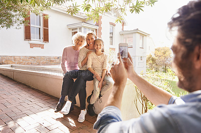 Buy stock photo Picture, family and happy grandma, mother and child bonding, smile and father taking outdoor generations photo. Cellphone, support and happiness of young kid, mom and elderly grandma in home backyard
