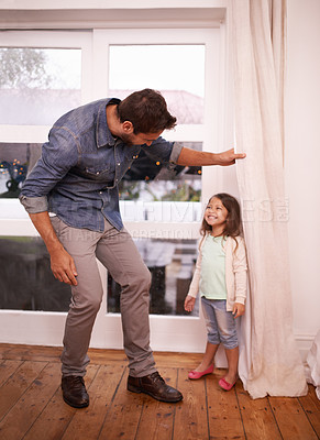 Buy stock photo A handsome young father playing hide and seek with his young daughter