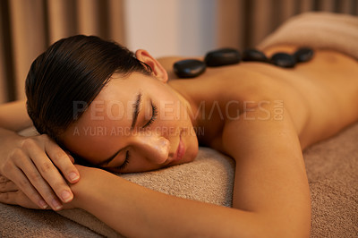 Buy stock photo A young woman enjoying hot stone therapy at the spa