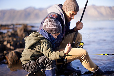 Buy stock photo Water, fisherman and father with son, bonding and dad teaching boy in lake to catch fish together. Parent, male person and man with kid for nature in countryside, adventure and learning for child