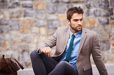 Buy stock photo Shot of a handsome and stylish young businessman in an urban setting