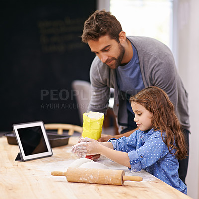 Buy stock photo Shot of a father and daughter baking together in the kitchen