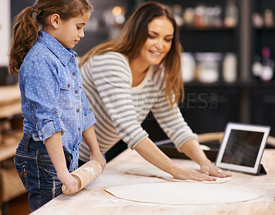 Buy stock photo Pizza, dough and child with mother in kitchen and tablet for recipe, guide and learning from online tutorial. Cooking, together and girl help with rolling pin and baking with mom in home for dinner