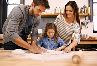 Buy stock photo Shot of a happy family of three baking together in the kitchen
