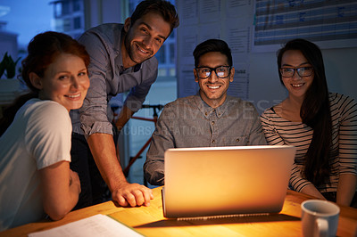 Buy stock photo Shot of coworkers working into the evening in the office
