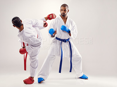 Buy stock photo People, karate and kick with training in studio on white background to fight or practice for competition. Mma, sport and kick with glove for fitness, commitment and confidence with focus as fighters 