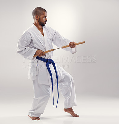 Buy stock photo Karate, fight and man with nunchucks in martial arts, studio or training with weapon for defence on white background. Nunchaku, exercise and fighting with equipment in sport with skill and power