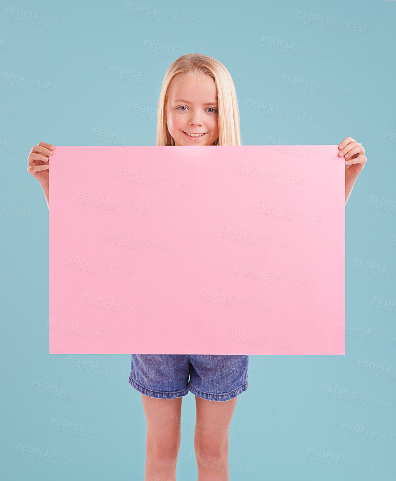 Buy stock photo Child, portrait and poster mockup in studio as billboard presentation for placard on blue background, announcement or board. Female person, face and smile or information banner, contact us or paper