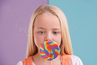 Buy stock photo Child, lollipop and candy in studio for snack dessert or birthday food or mockup, sugar or unhealthy. Female person, colour spiral and split purple or blue background or sweets, meal or delicious