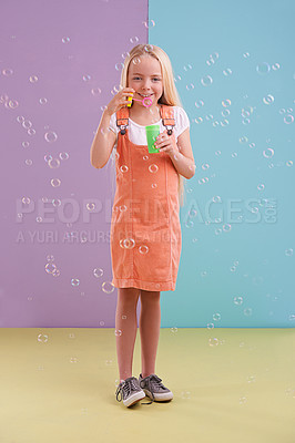 Buy stock photo Fun, playing and girl blowing bubbles in studio with activity for child development and hobby. Youth, toy and young kid model with casual, cool and trendy style isolated by color block background.