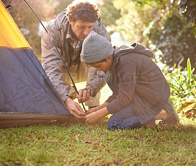 Buy stock photo Dad, child and preparing tent for camping outdoor in nature on vacation while bonding in summer sunset. Father, boy and setting up camp, learning and getting ready in forest for adventure or travel.
