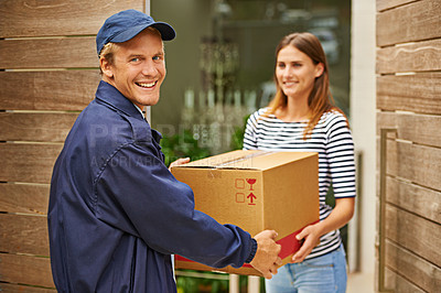 Buy stock photo Shot of a male courier delivering a package to a woman at her home