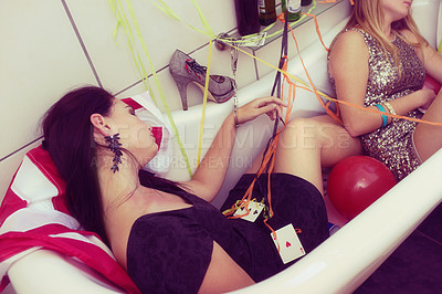 Buy stock photo Party, bathroom and hangover with woman friends sleeping in a bath after a new year celebration or event. Birthday, spring break and college with a female and friend lying in a bathtub from above