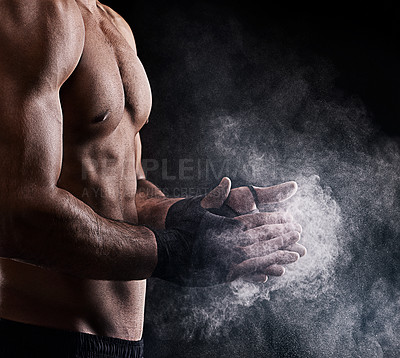 Buy stock photo Cropped shot of a man dusting powder on his hands as he prepares to box