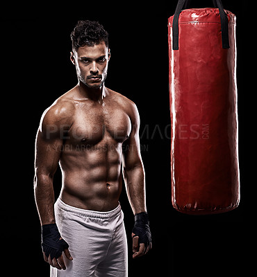 Buy stock photo Serious, boxer and portrait of man, punching bag and gloves for training with strength and muscle. Adult, athlete and male person in dark background, healthy and power with body, sport and studio