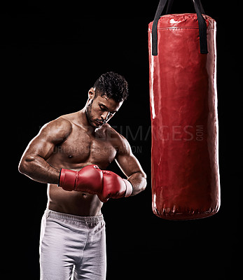 Buy stock photo Hands, boxing bag and gloves for male boxer, studio and  athlete on black background. Dark, training and combat sports or MMA for man model, workout, muscle and impact activity for martial arts