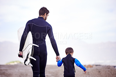 Buy stock photo Surfboard, man and kid on beach, holding hands and walking on outdoor bonding adventure. Nature, father and son at ocean for surfing, teaching and learning together with support, trust and growth.
