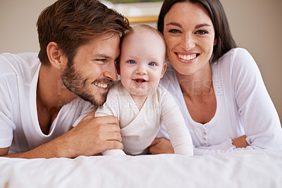 Buy stock photo Portrait, happy family and parents with baby on bed for love, care and quality time together at home. Mother, father and newborn child relaxing in bedroom for development, caring support or happiness