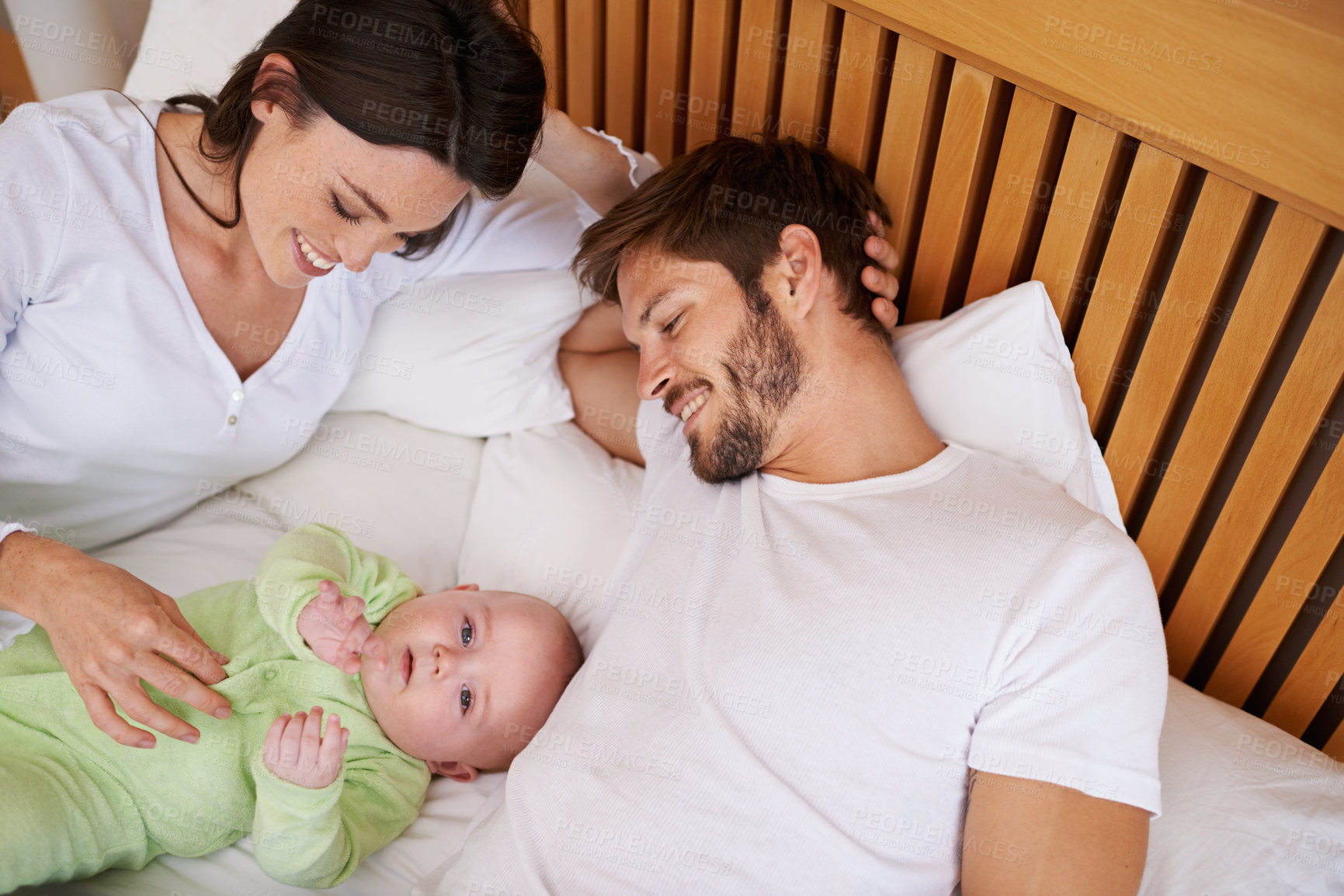 Buy stock photo Above of mother, father and baby in bedroom for love, care and quality time together at home. Happy parents, family and newborn kid relax on bed with support, childhood development and fun bonding 