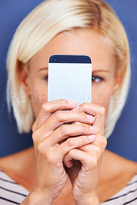 Buy stock photo Woman, typing and browsing with phone for social media, communication or networking on a blue studio background. Female person or blonde on mobile smartphone for online chatting or texting on app