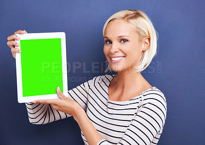 Buy stock photo Studio shot of a young woman holding up a digital tablet with a chroma key screen