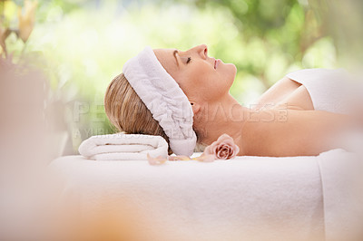 Buy stock photo Woman, spa and break for zen, peace and wellness with relaxation and calm. Lady, towel and massage table at resort, lounge or luxury parlor with rose for holistic body and skincare for detox and rest