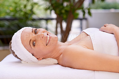 Buy stock photo Happy woman, portrait and relax with towel for spa, zen or massage table at hotel or outdoor resort. Face of female person with smile, enjoying facial or body treatment at accommodation for wellness