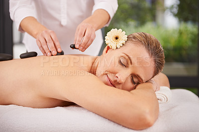 Buy stock photo Person, spa and hands with hot stone for massage, wellness and relax in hotel. Physical therapy, holistic and woman or girl in holiday or vacation in California for health, peace and back skin detox