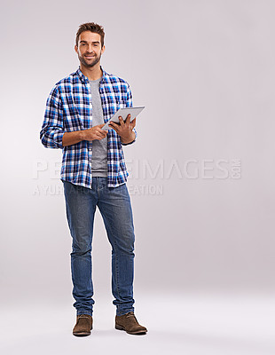 Buy stock photo Typing, tablet and man with connection, portrait and communication on a grey studio background. Person, mockup space and model with technology or digital app with social media, smile and website info