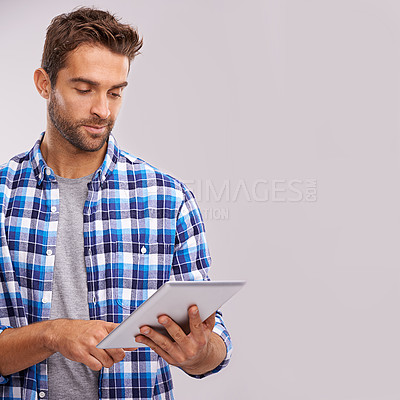 Buy stock photo Typing, tablet and man with connection, internet and digital app on a grey studio background. Person, mockup space and model with technology or communication with social media and website information