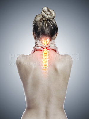 Buy stock photo Rearview shot of a woman holding her back in pain