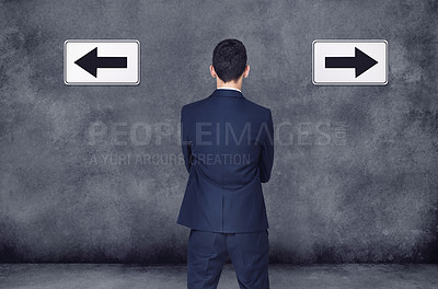 Buy stock photo Back, arrow and direction with a business man planning or brainstorming a decision while in doubt on a wall background. Confused, challenge or strategy with a male employee thinking of a solution