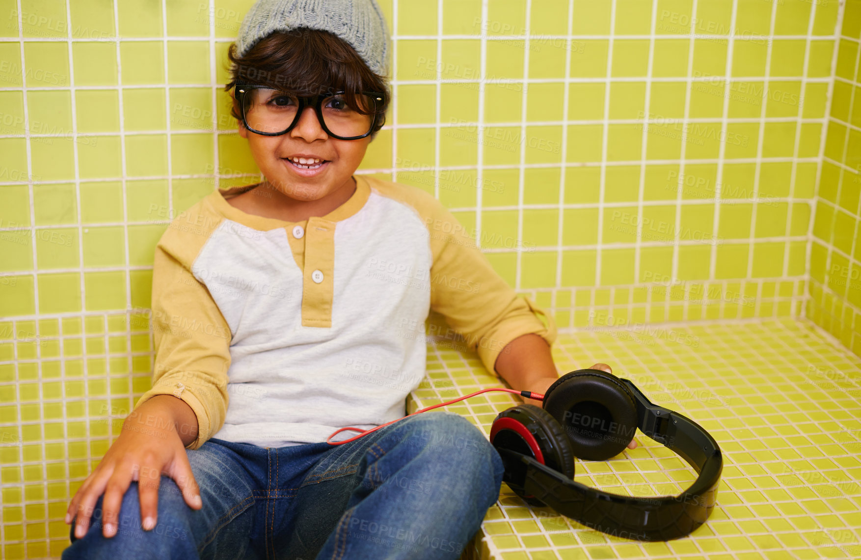 Buy stock photo Child, portrait and glasses with cool headphones in bathroom with music in a home. Radio, eyewear and youth fashion with a hipster boy listening to audio with with style in a house with frames