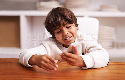 Buy stock photo Phone, app and happy boy in a kitchen for google it, gaming or sign up at home. Smartphone, smile or Indian kid person in a house online for streaming, video or cartoon, movie or Netflix and chill