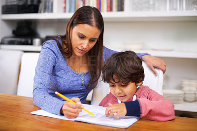 Buy stock photo Mother, help and child with book for homework, learning and education for grades, study and development. Indian people, woman and boy with note and pencil for teach, writing and childhood in house