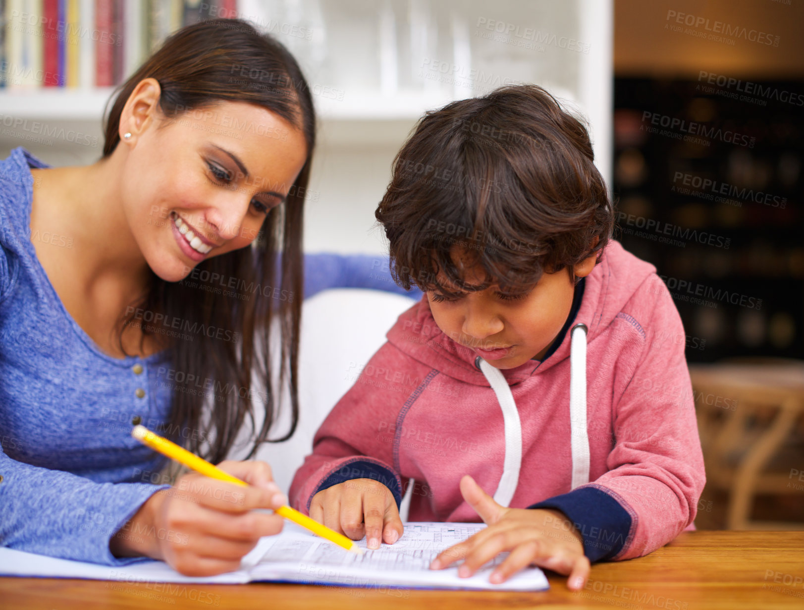 Buy stock photo Shot of a mother helping her son with his homework