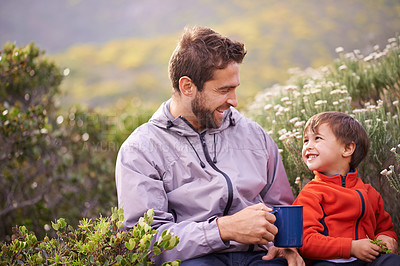 Buy stock photo Shot of a happy father and son having something to drink while on a hike together