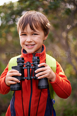 Buy stock photo Portrait of a happy young boy out in the woods with a pair of binoculars