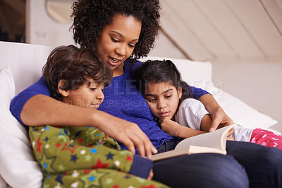 Buy stock photo Mother, children and reading a book in a family home for story time on a lounge sofa with a smile. A woman or mom with kids together for development, learning and love with a fantasy or fairytale