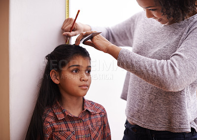 Buy stock photo Mother, child and measuring height at wall for growth development in home for childhood, love or bonding. Female person, daughter and pencil with ruler apartment for size checking, youth or parent