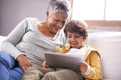 Buy stock photo Tablet, grandmother and child education app at home on living room sofa with happiness and bonding. Family, house couch and lounge with senior woman and kid on technology watching a video with smile