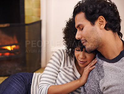 Buy stock photo Couple, fireplace and relax in embrace, home and peace or calm and proud of marriage or commitment. People, holding and hugging on floor in lounge on weekend, support and trust in relationship