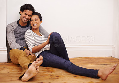Buy stock photo Full length shot of an affectionate young couple sitting on the floor at home