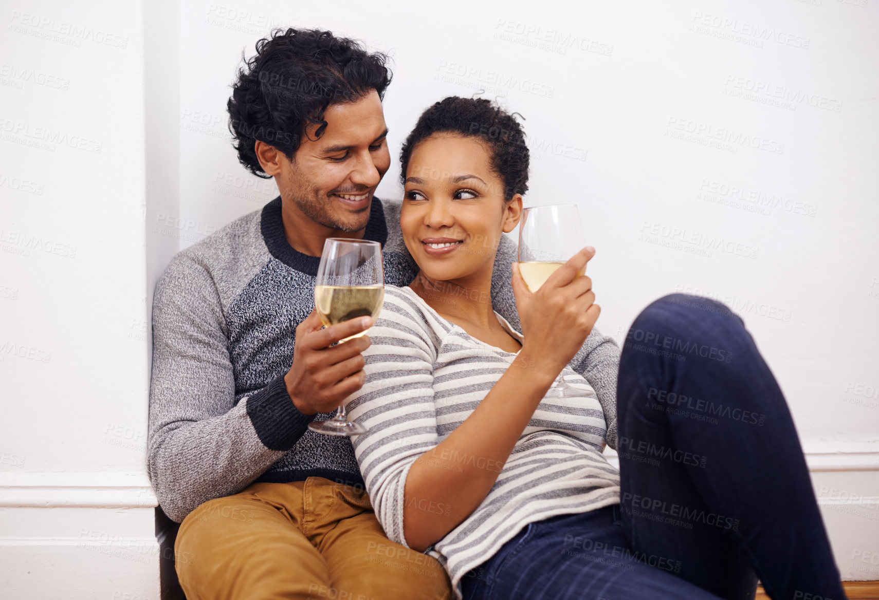 Buy stock photo Couple, floor and wine to relax and embrace in home, smile and proud of marriage and commitment. People, milestone and drinking in living room on weekend, support and celebration for relationship